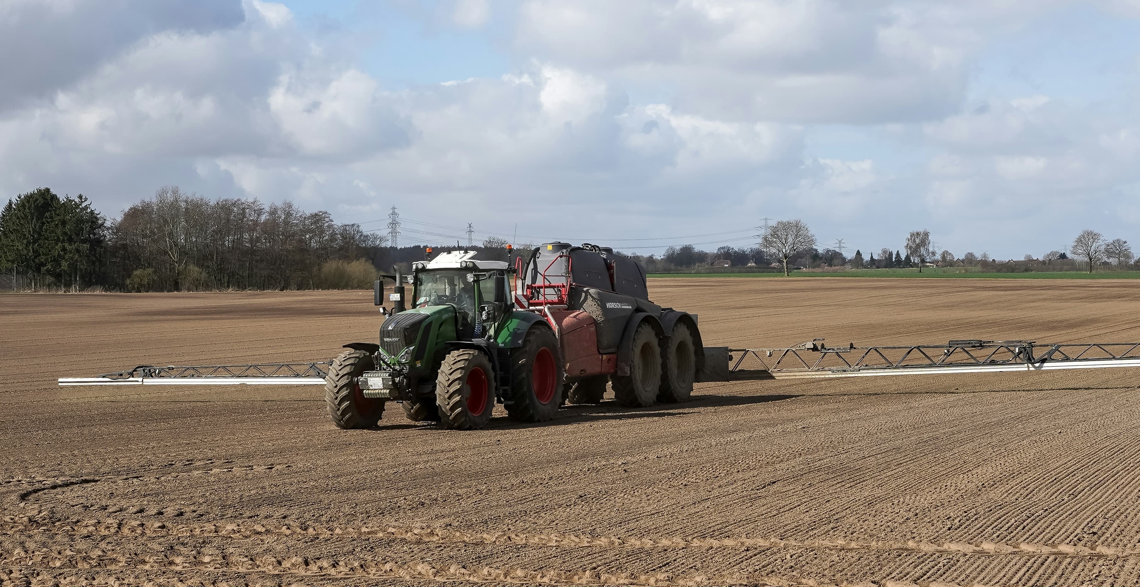 Tractor ploughing a broad open field, symbolising careful preparation and laying the groundwork before acting.